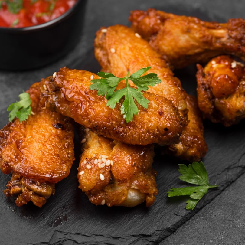Centralia's Chicken & Fish Italian Beef fried chicken wings with sesame seeds and parsley, with dipping sauce.
